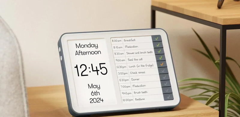 Relish Day Hub dementia clock on a living room side table showing Monday Afternoon and a task list 