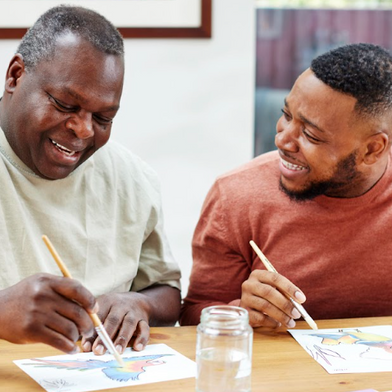 A father and son are enjoying painting, which is a great activity for seniors to do alone or as a group activity.