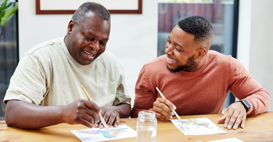 A father and son are enjoying painting, which is a great activity for seniors to do alone or as a group activity.