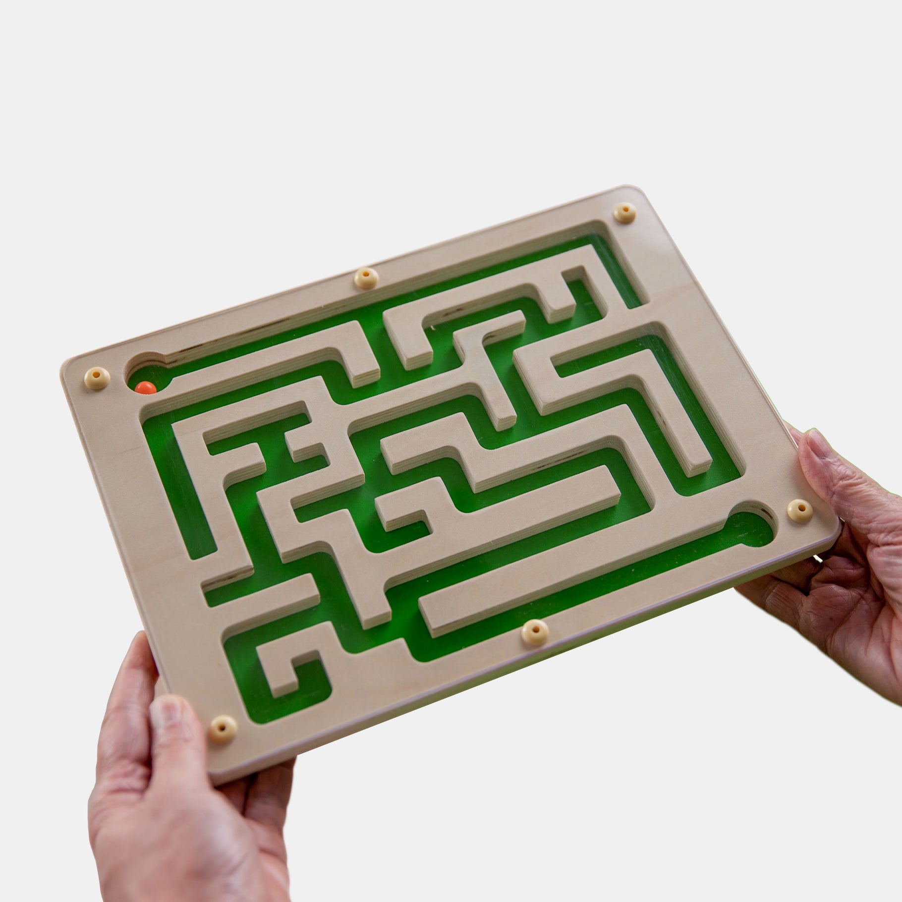 Hands holding a maze board, ideal for dementia activities, care home activities, and gifts for people living with dementia.