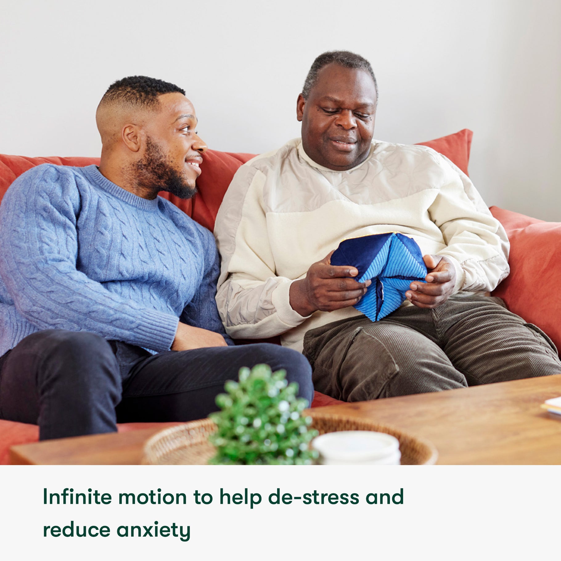 an adult son and father sat on sofa with a Relish Tactile Turn