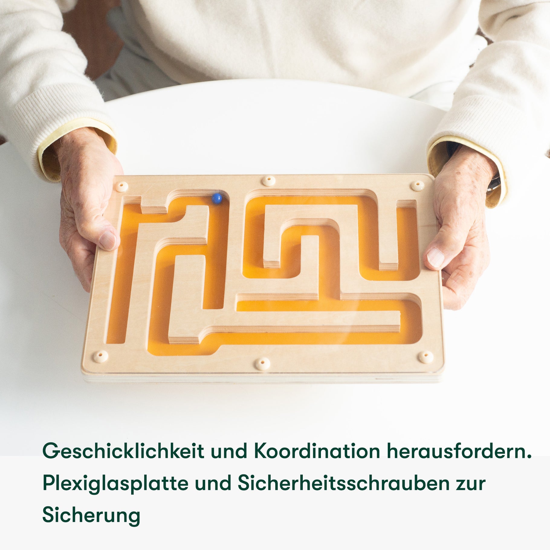 Elderly hands hold a wooden maze, a dementia activity promoting coordination, ideal for care homes and Alzheimer's patients.