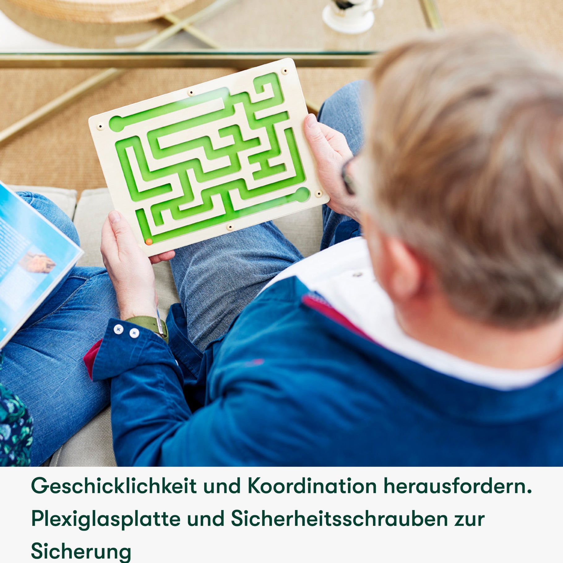 Elderly man engages with a maze board game, ideal for dementia activities and care home residents' cognitive stimulation.