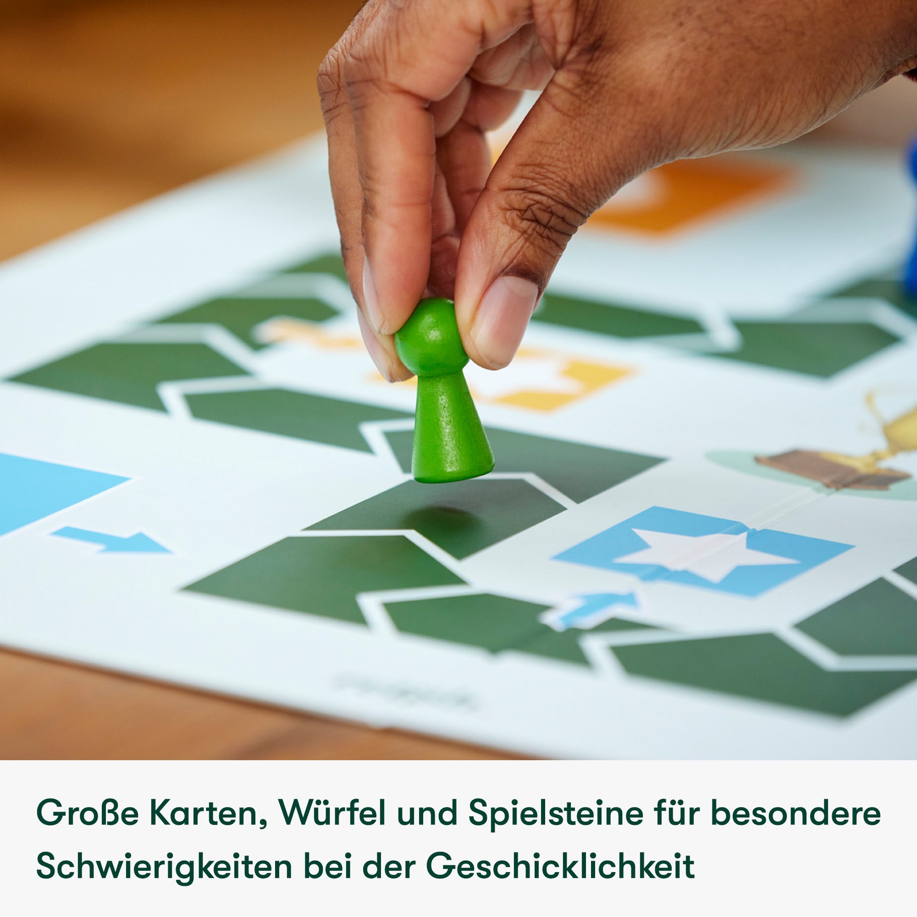 A hand places a green game piece on a board, illustrating activities for dementia patients and care home residents.