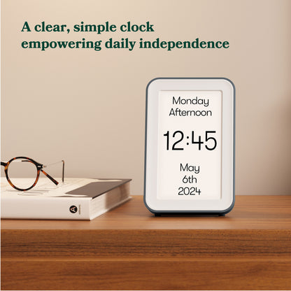Day Connect dementia day clock on bedside table displaying time, date, and day. Designed for people with Alzheimer's or dementia. Image caption: A clear, simple clock empowering daily independence