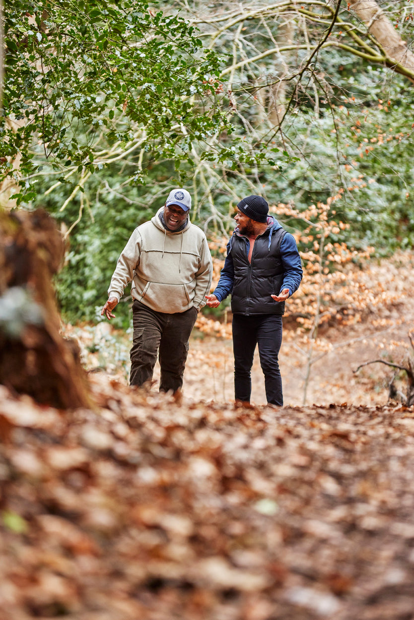 A father and his adult son walk in woods