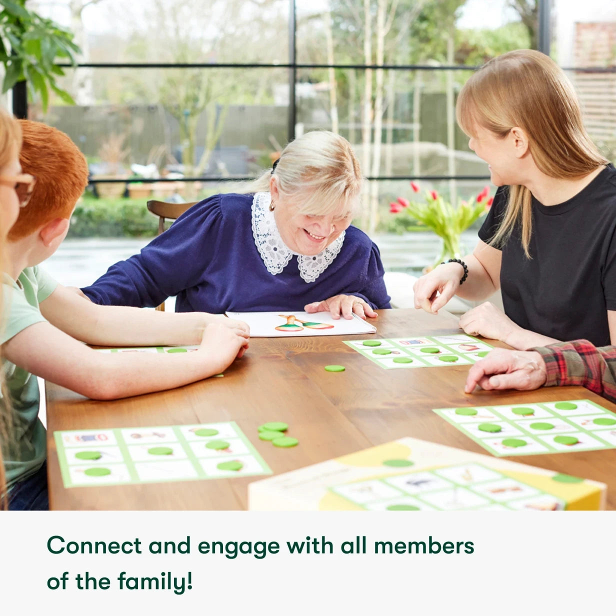 Elderly woman with dementia enjoys a board game with family, showcasing activities for care homes and people living with dementia.