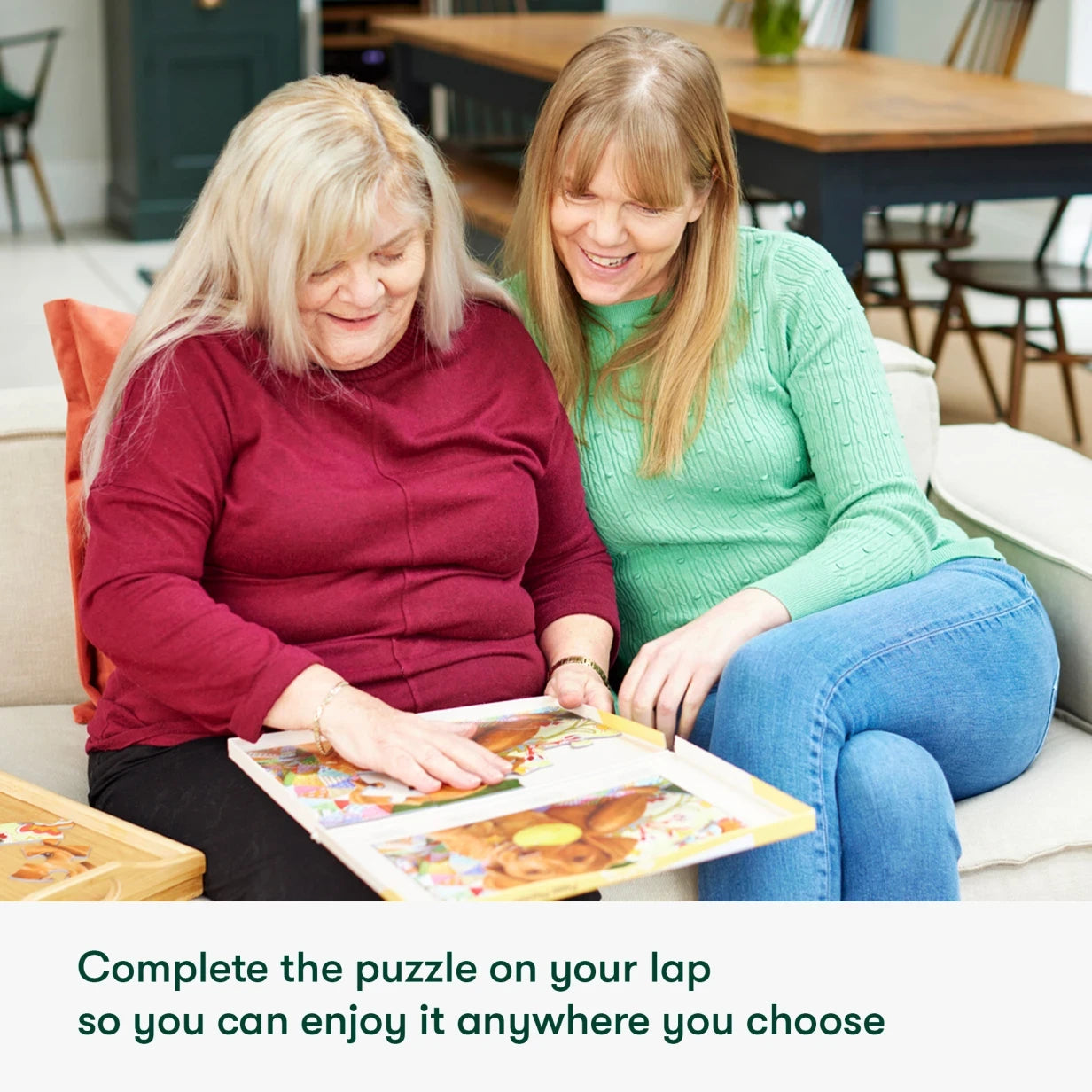 Elderly woman and caregiver enjoy a puzzle, ideal for dementia activities and care home engagement, fostering connection and joy.