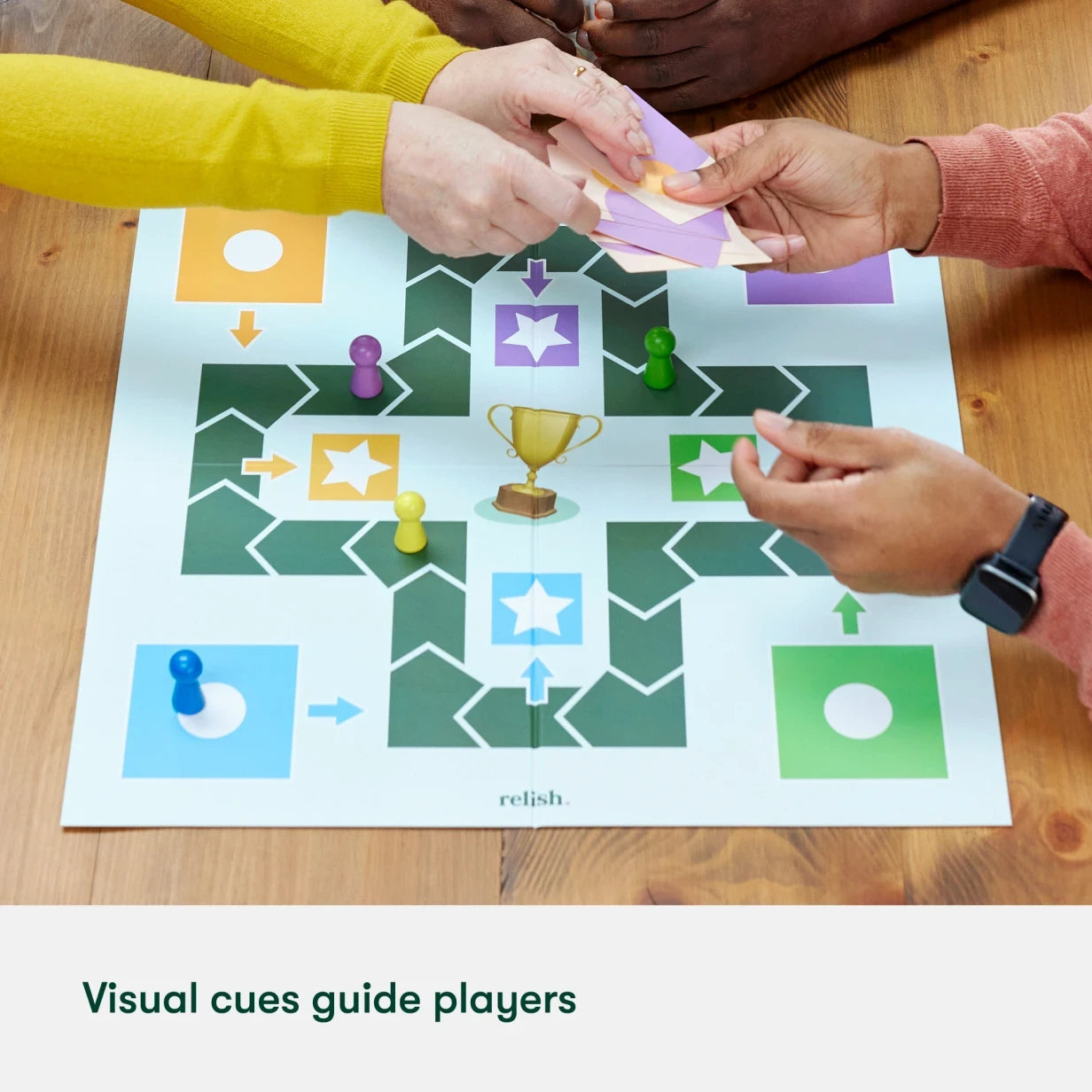 Hands playing a colourful board game designed for people with dementia, featuring visual cues and simple instructions.