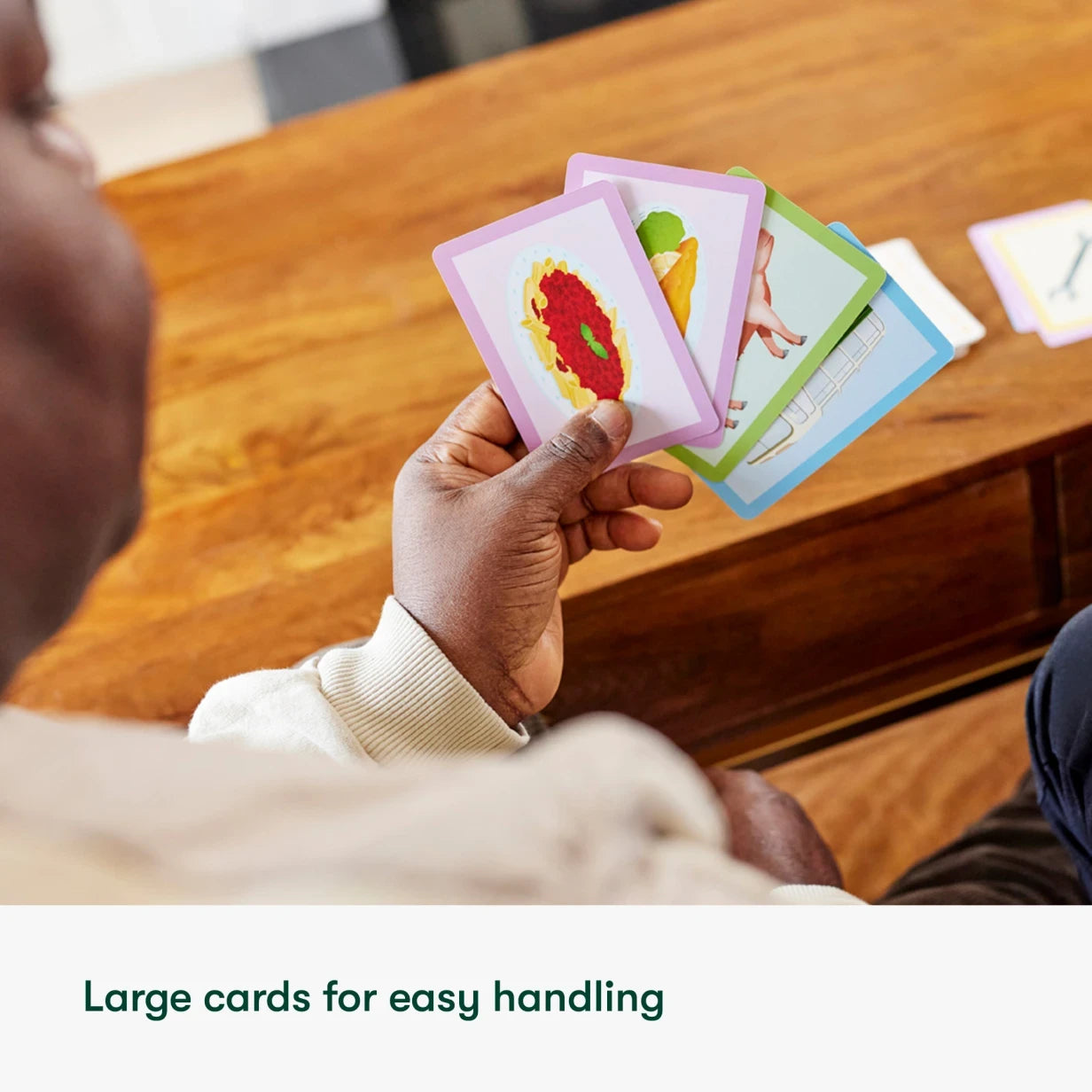 Man holding large cards for dementia activities, ideal for care homes and elderly engagement.