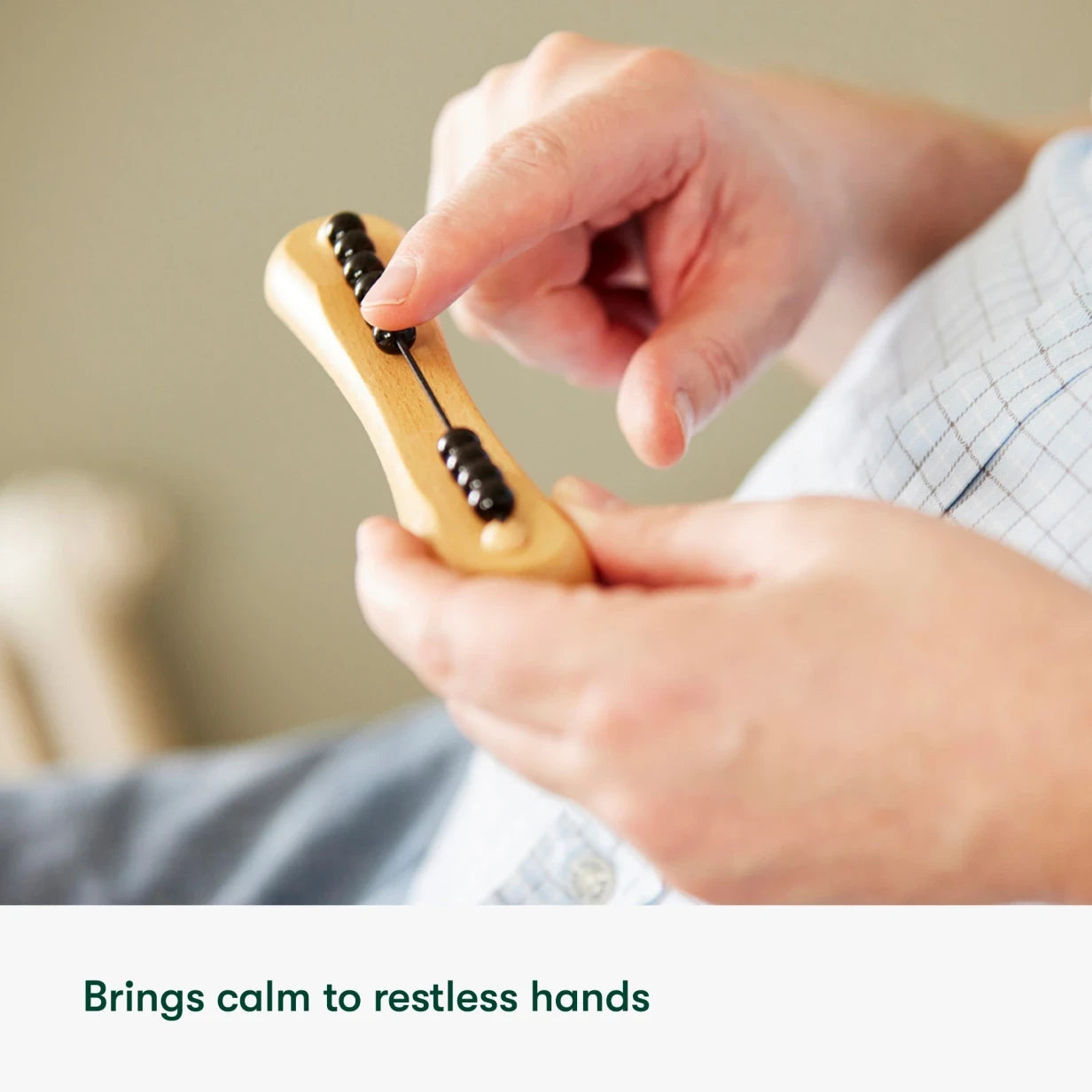 Elderly hands using a fidget toy, ideal for dementia activities, providing calm and engagement for care home residents.