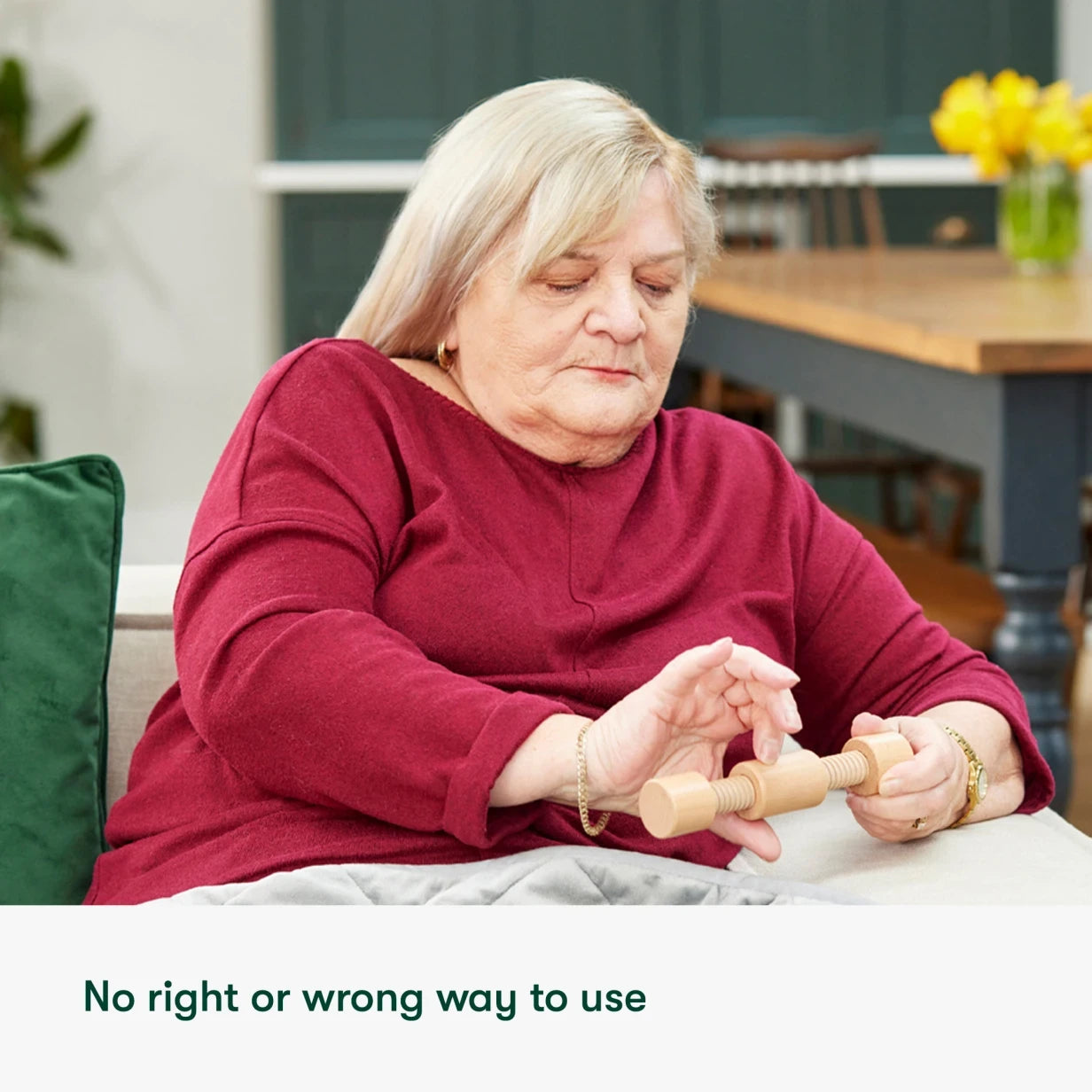 Elderly woman using a fidget toy, ideal for dementia activities in care homes, promoting engagement and calm for people living with dementia.