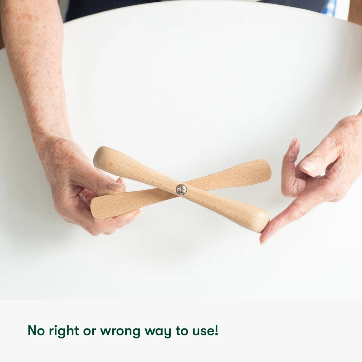 Hands holding a wooden fidget toy, ideal for dementia activities and care home residents, promoting engagement and calm.