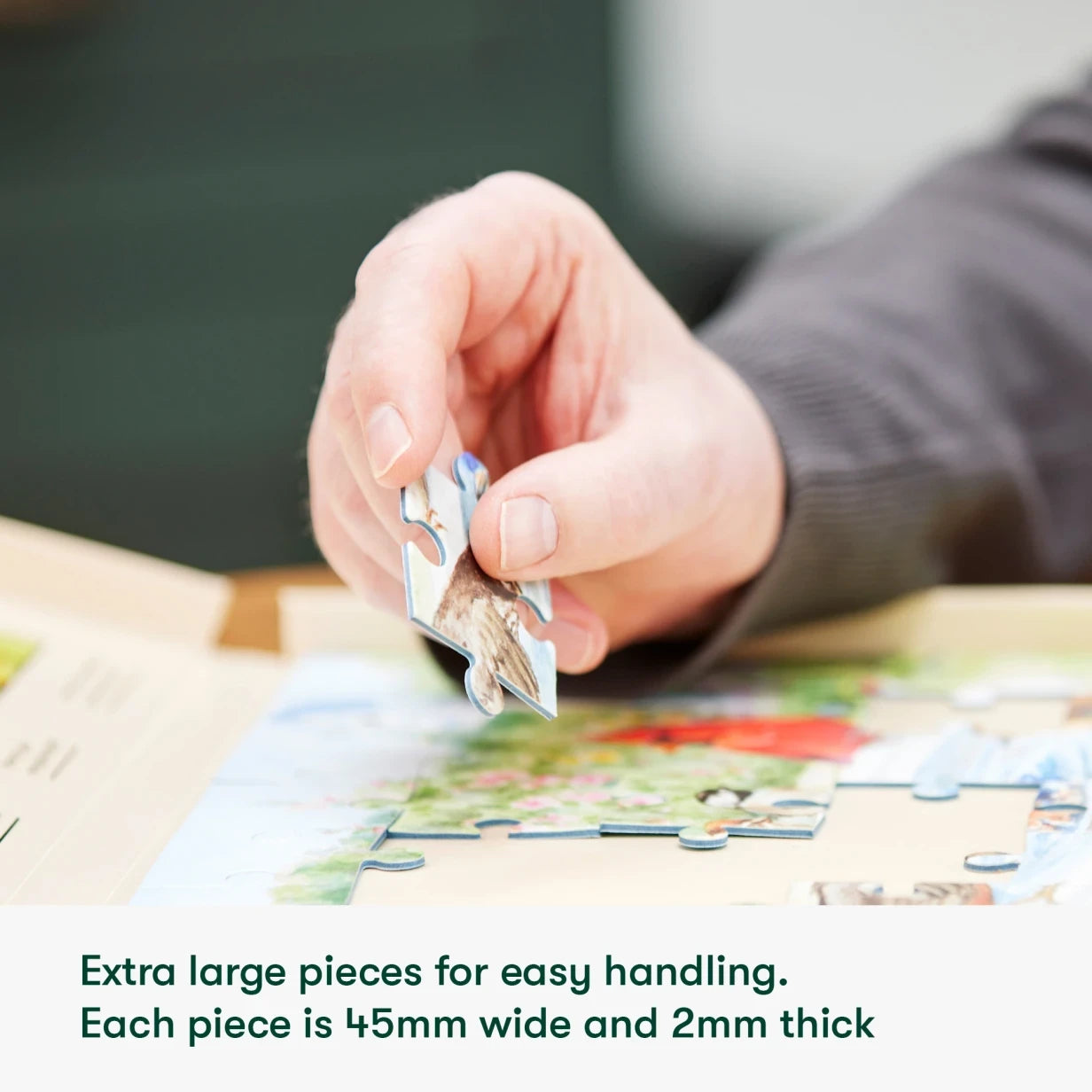 A hand assembles a large puzzle, ideal for dementia activities, care home residents, and elderly engagement.